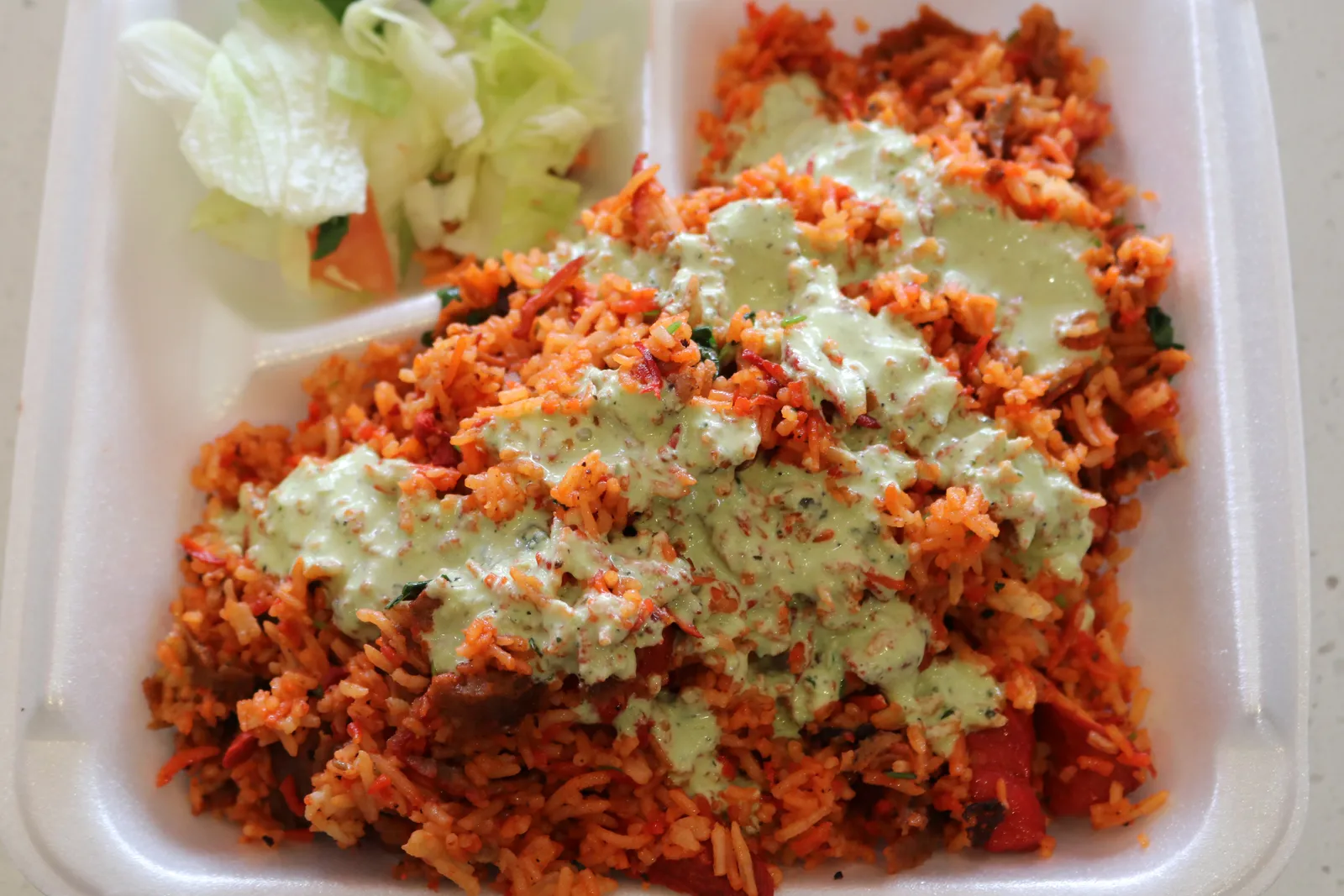 Rice plate with green sauce and salad
